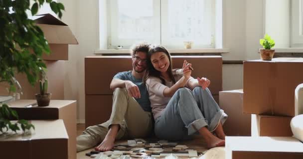 Happy homeowners family holding keys smile pose for camera — Vídeo de Stock