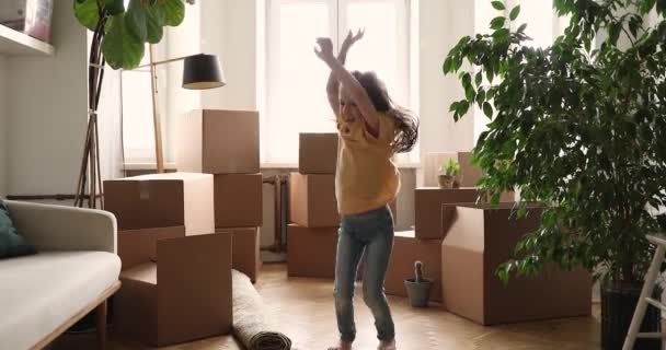 Little girl have fun on relocation day jumping near boxes — Stok video