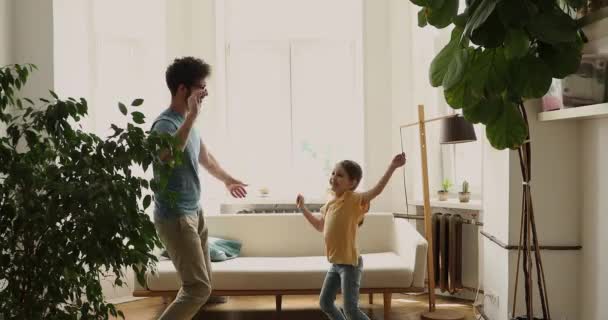 Young father dancing in living room with little cute daughter — стоковое видео