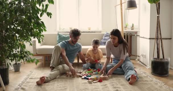 Young couple and daughter play wooden toys at home — 비디오