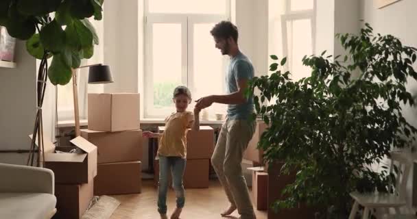 Happy father and daughter dancing in living room near boxes — Stok video