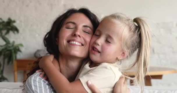 Closeup portrait loving mother cuddling cute little daughter — Stockvideo