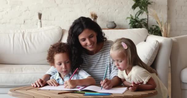 Mom or babysitter drawing pictures with diverse kids at home — Stock video