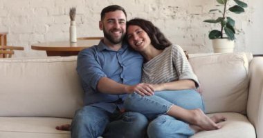 Cheerful couple relaxing at home looking aside enjoy weekend leisure