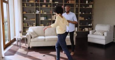 Romantic Black couple dating at home dancing on warm floor