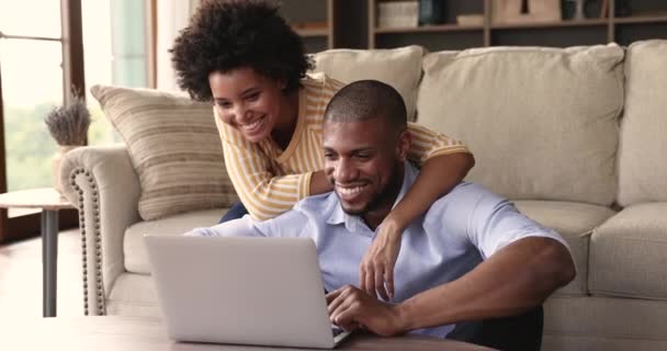 Young Black couple in love cuddling watching video on laptop — стокове відео