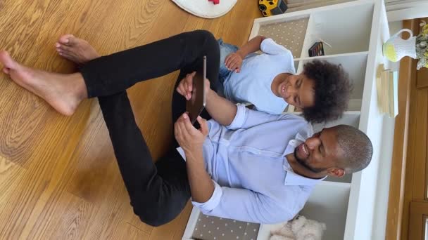 African dad browse web online with little son using touchpad — 图库视频影像