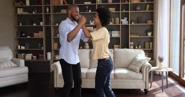 Happy millennial Black couple enjoy modern dance at living room — стоковое видео