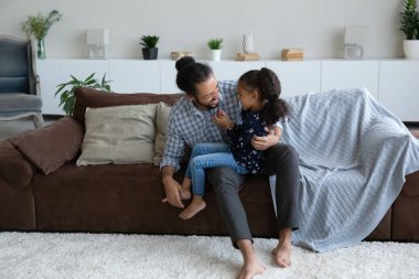 Happy loving dad holding little kid in arms on lap