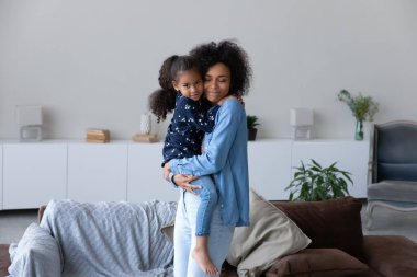 Happy African mom holding little daughter girl in arms