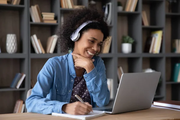 Cheerful laughing student girl in headphones watching learning virtual webinar — стоковое фото