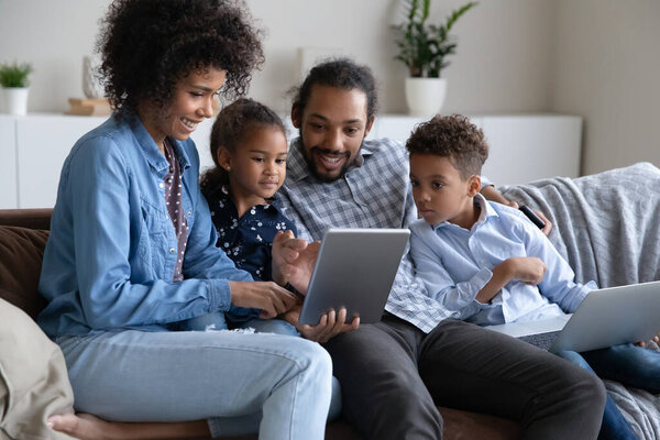 Happy family spending leisure time with digital devices at home