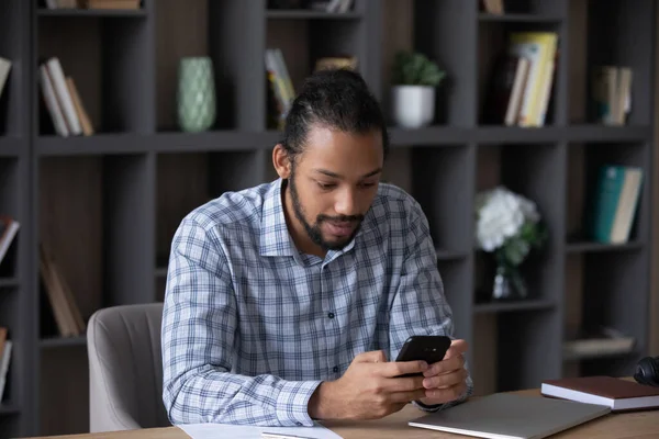 Focused busy millennial Black business man browsing internet on smartphone — Fotografia de Stock
