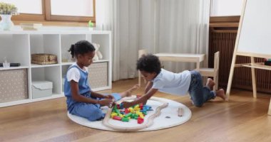 Afro American kids elder sister younger brother constructing from bricks