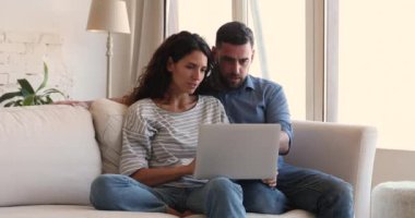 Couple check email on laptop, receive great offer feel overjoyed