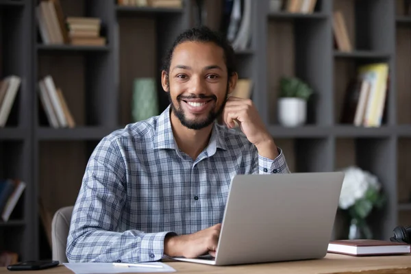 Happy Afro American entrepreneur guy sitting at desk — Stockfoto