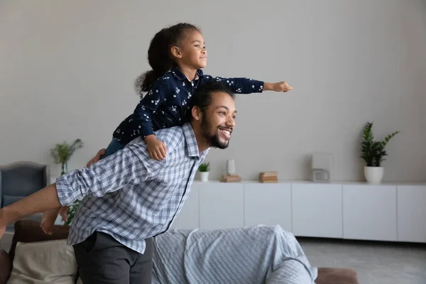 Happy African American dad piggybacking excited proud daughter kid — 图库照片