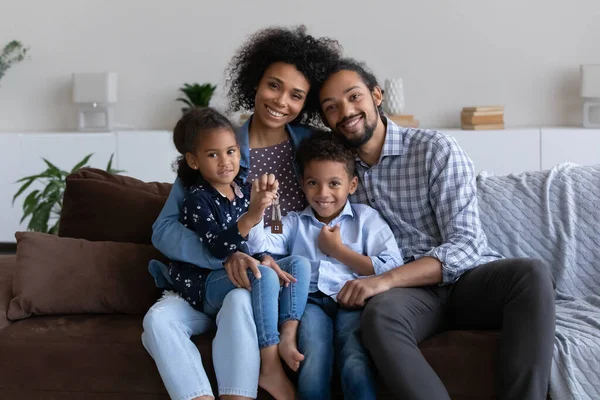 Happy young African parents and two little kids holding keys — Foto de Stock