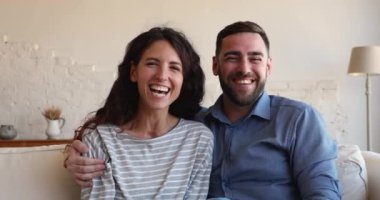 Beautiful young couple talk to family using videocall application