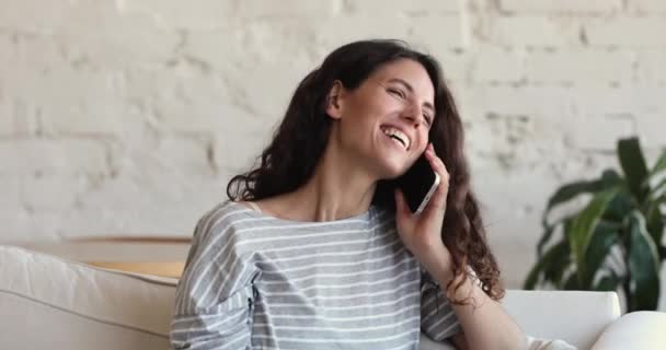 Happy young Latina woman answers on phone call at home — Stockvideo