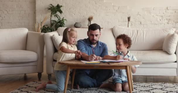 Loving father drawing pictures with diverse kids at home — kuvapankkivideo