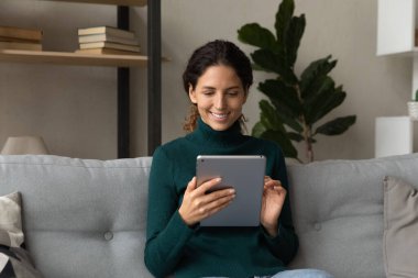 Happy young latin woman using digital tablet.