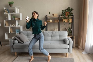 Overjoyed sincere young woman dancing to energetic music.