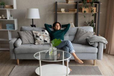 Relaxed young woman napping on comfortable sofa.