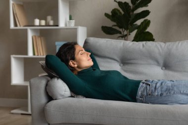 Relaxed young attractive hispanic woman sleeping on cozy sofa.