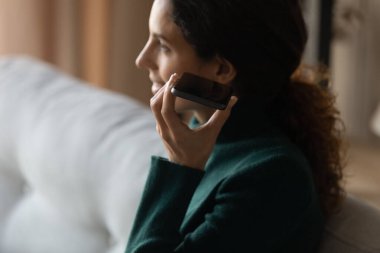 Close up young woman listening audio message from cellphone.