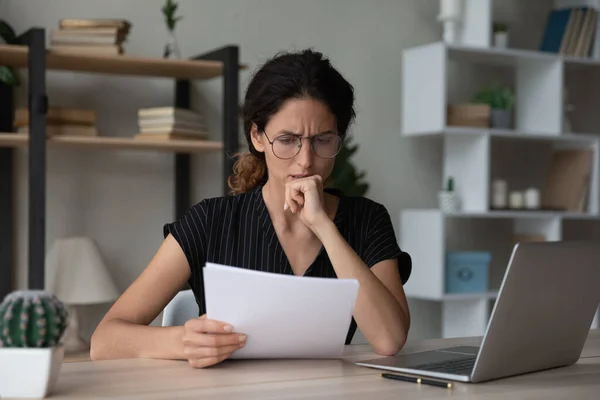 Mujer joven infeliz preocupada leyendo carta de papel con malas noticias. — Foto de Stock