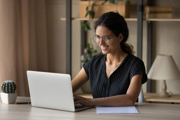 Happy attractive millennial businesswoman working on computer at home office. — Foto de Stock