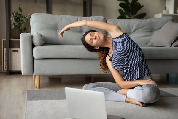 Mujer feliz pacífica practicando ejercicios de yoga en casa. — Foto de Stock