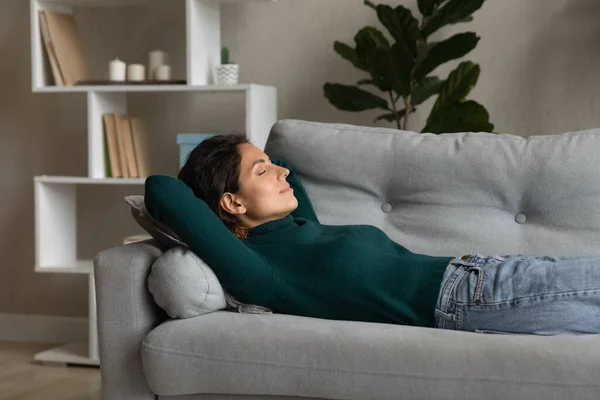 Relaxed young attractive hispanic woman sleeping on cozy sofa. — Stok Foto