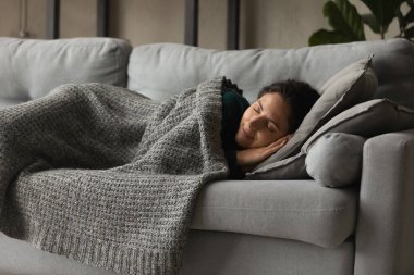 Happy mindful millennial sleeping under blanket at home.