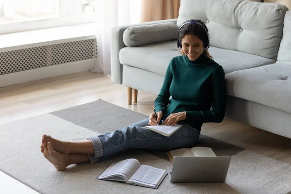 Happy millennial woman studying distantly, sitting on floor. — Stock fotografie