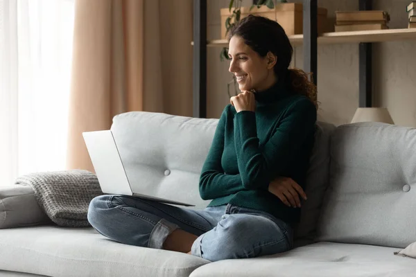 Happy relaxed millennial latina woman using computer at home. — Stock fotografie