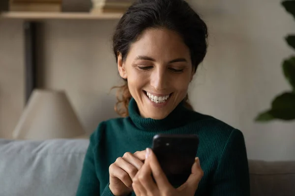 Happy young attractive woman using cellphone at home. — Stock Photo, Image