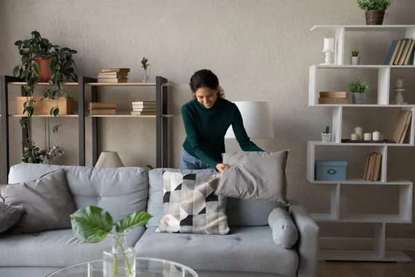 Happy young beautiful woman cleaning living room.