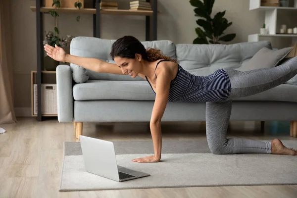 Happy fit young woman in active wear watching yoga webinar. — Stok Foto