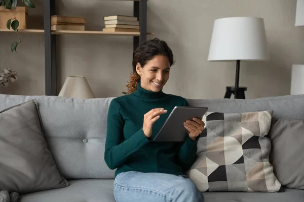 Happy young hispanic woman using digital tablet at home. — Stockfoto