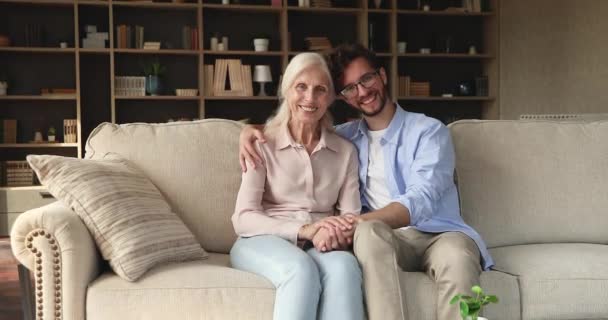 Older woman her adult son smile look at camera — Stock video