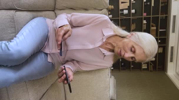 Vertical view older woman use cellphone and card buying online — Stock video