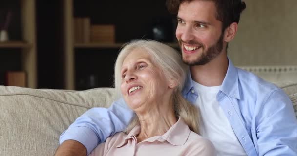 Closeup dreamy older woman her adult son relax on sofa — Vídeos de Stock