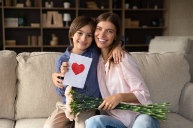 Little son congratulates young beautiful mom on her birthday