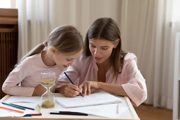 Mother and daughter drawing in sketchbook with colored pencils — Stockfoto