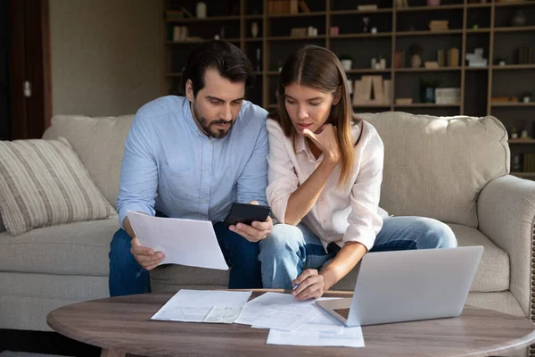 Young couple calculates expenses, managing family budget — ストック写真