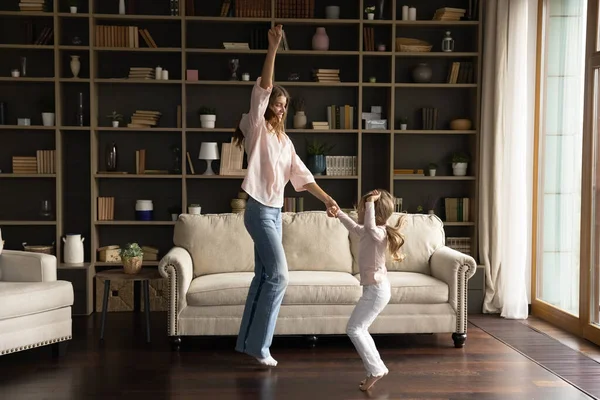 Gelukkig moeder en dochter dansen in woonkamer — Stockfoto