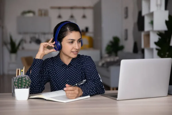 Focused smiling Indian student girl in headphones studying from home — Stok fotoğraf
