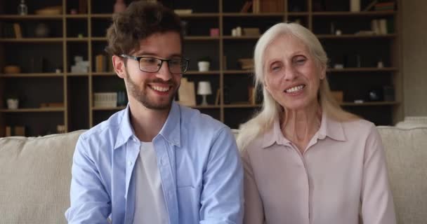 Multigenerational family making videoconference call sit on sofa at home — 비디오